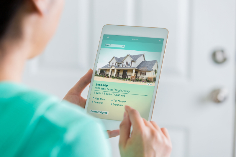 A man browsing homes for sale listings using tablet